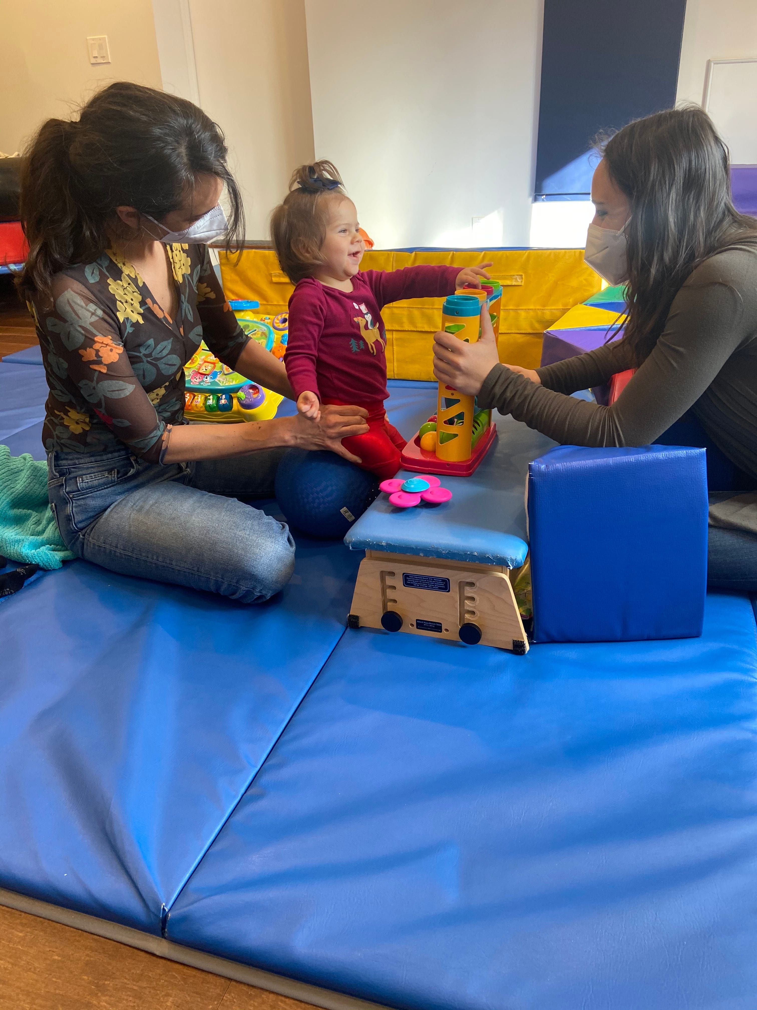 Two Therapist Playing With Little Girl